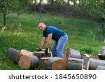 Small photo of Strong lumberjack manhandling the logs