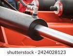 Small photo of Black piston or actuator in red pneumatic or hydraulic machine. Technology and engineering