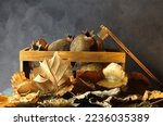Small photo of RUSTIC IMAGE WITH SMALL WOODEN CRATE AND OLD SPOILT FRUIT WITH DRY LEAVES