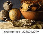 Small photo of OLD DRY LEAVES WITH SEED PODS AND SPOILT DRY FRUIT AND A WOODEN BOWL