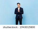 Smiling young handsome southeast Asian man clapping hands impressively in light blue studio isolated background