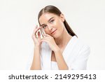 Beauty shot portrait of attractive Caucasian woman with smooth skin looking at camera on white isolated background in light studio
