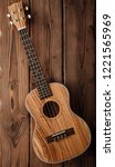 Small photo of beatiful tenor ukulele made of zebrawood on aged dark wood background