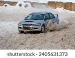 Small photo of Tukums, Latvia - January. 7. 2023: Youngsters practice safe driving on a winter track with the Mitsubishi Lancer Evo street sports car