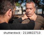 Small photo of Two men quarrel and fight. Two thugs are fighting. Physical confrontation of people outside on the street