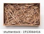 Open brown box with shredded paper above top view isolated