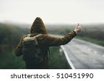 Man hitchhiking on road in autumn fog