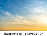 Beautiful bright orange - yellow cloudy sky during the sunrise and sunset. Beautiful scenic gradient sky between hot and cool tone of twilight sky with a cloud. Sun beam background.