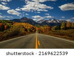 Small photo of Sunny autumn afternoon scenic drive in the San Juan Mountains near Telluride Colorado with snow covered peaks in distance, yellow and orange Aspen trees near peak fall color - horizontal orientation