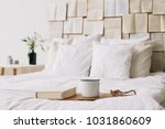 Spring still life. Breakfast in bed. White bedroom. Sweet home. Books, flowers and coffee cup. flat lay