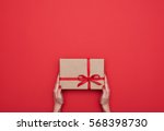 Top view of female hands holding present box package in the palms isolated over flat lay background 