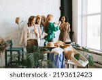 Small photo of four young woman female caucasian and african students at swap party try on clothes, bags, shoes and accessories, change clothes with each other, second hand for things, zero waste life, eco-friendly