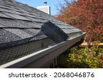 Small photo of Roll of plastic mesh guard over gutter on a roof to keep it free from leaves and debris, shallow focus on roll of mesh