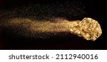 Small photo of Piece of gold or golden nugget with visible gold shining comet tail ath the dark background.