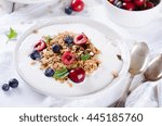 Healthy breakfast of homemade granola with yogurt and berries on white background