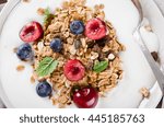 Healthy breakfast of homemade granola with yogurt and berries on rustic background