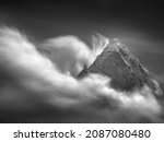 Black and white landscape with mountains peak and moving clouds in long exposure in vintage style
