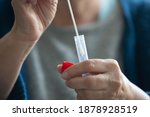 Unidentified senior woman performing a swab test for coronavirus covid-19 and preparing a package for laboratory testing.