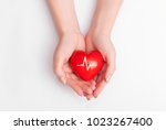 People health concept - close up of woman's cupped hands showing red heart with heart beat.