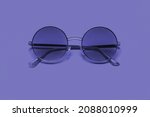 Beautiful trendy sunglasses on a pink background. New 2022 trending PANTONE 17-3938 Very Peri color
