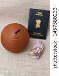 Small photo of Indian Passport and Kids piggy bank or coin stack jar for money savings cash deposit for future. Success and profit from business. new currency bank note Rs. 2000, 500 of India for making world tour.