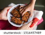 Small photo of Woman serving homemade Christmas plum cake in a plate and a kid taking a piece of cake. Fruitcake made with dried fruit, nuts, spices and rum for New Year party, Easter celebration Christmas Eve etc.