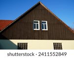 Hazardous asbestos on an old house gable. Old building material for wall cladding. This material is banned because of the cancer risk posed by the microfibers. Village of Juehnde, Germany.