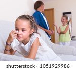 Small photo of Upset crying little girl is jealous sister of stepbrother indoors