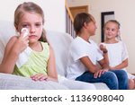 Small photo of Cute little girl is jealous sister of stepbrother and crying indoors