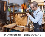 Qualified workman upholstering chair in repair furniture workshop