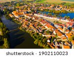 View from drone of historical houses and town square of small Czech city Telc surrounded by ponds in sunny fall day