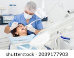 Practitioner male dentist drilling tooth to female patient in dental studio
