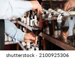 Small photo of Bartender hand pouring draught red wine to glass. High quality photo