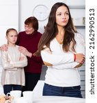 Small photo of Chagrined young woman having conflict with little daughter and mother