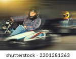 Man in helmet driving racing car for karting in a circuit lap in sport club, people on background