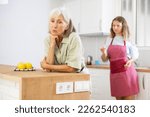 Small photo of Aggrieved elderly woman having quarrel with her daughter in kithcen at home.
