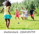 Small photo of Cheerful tween friends gaily spending time together on sunny summer day, playing with ball outdoors..