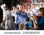 Small photo of Portrait of cheerful tipsy businessman drinking alcohol and having fun at corporate party in nightclub