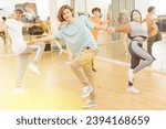 Small photo of Teenager girls and boys performing jive dance in ballroom.