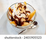 Small photo of Poire belle Helene, peeled sliced pear poached in syrup served in dessert bowl with vanilla ice cream dressed with chocolate sauce. Popular French dessert..