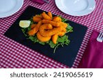 Small photo of Fried sepia in a batter of tempera flour with lemon and arugula