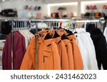 Small photo of Colorful array of male overcoat hang neatly on hangers, creating vibrant display in clothing store. From sports coat to cozy winter male jacket, assortment offers something for everyone
