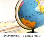 Small photo of Selangor, Malaysia - September 1, 2018: Countries and continents close up with the color map on a globe with books in the background. Education and travel concept.