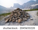 Large pile of rocks at the top of Grinnell Glacier Trail marks the summit of the trail, in Glacier National Park Montana