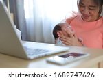 Small photo of businesswoman parenting a little baby newborn in business home office, mother using hand help her son belch burping after breastfeeding milk