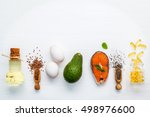 Selection food sources of omega 3 . Super food high omega 3 and unsaturated fats for healthy food. Olive oils ,salmon ,flax seeds ( linseed ) ,chia seeds ,eggs and avocado on white wooden background.