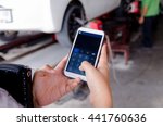 Close up hands of woman using mobile smart phone calculator application in the garage