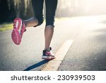 Sporty Woman Running On Road At ...