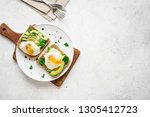 Small photo of Avocado Sandwiches with Poached Eggs - sliced avocado and egg on toasted bread for healthy breakfast or snack, copy space.