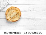 Crepes (Russian Blini) on white wooden background, top view, copy space. Homemade thin fresh crepes for breakfast or dessert.